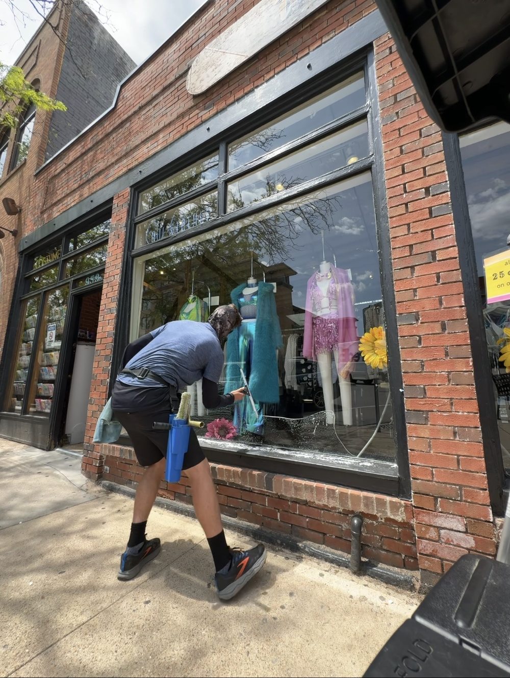 Barrett squeegeeing a storefront window on a brick building